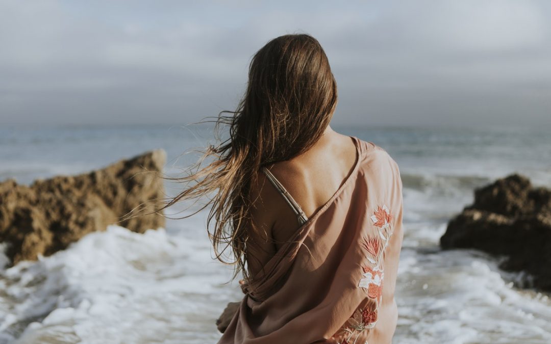 Back shot of woman in front of the beach